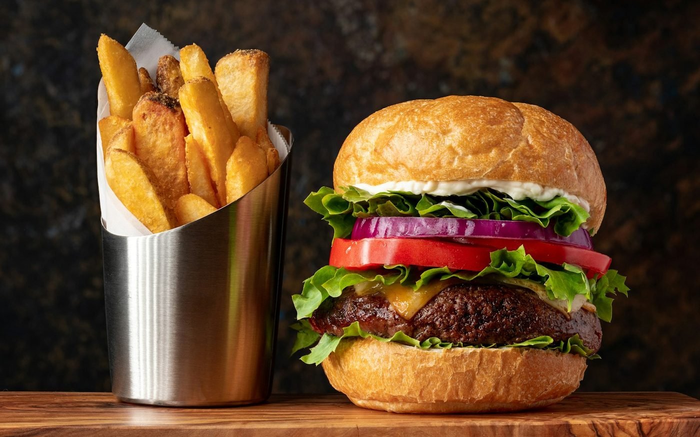 Burger served with a cup of golden fries