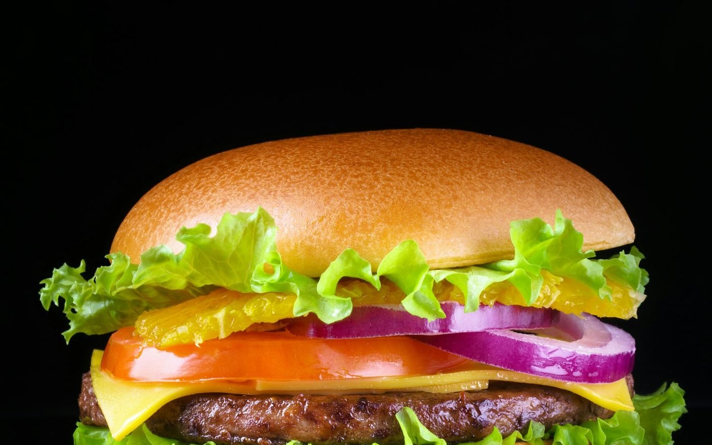 Burger with crisp lettuce, tomato, red onion and cheese