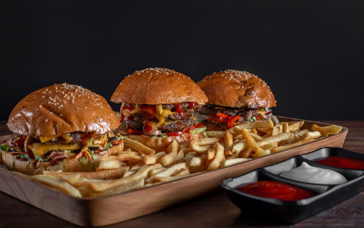 Several burgers and fries on a sharing platter